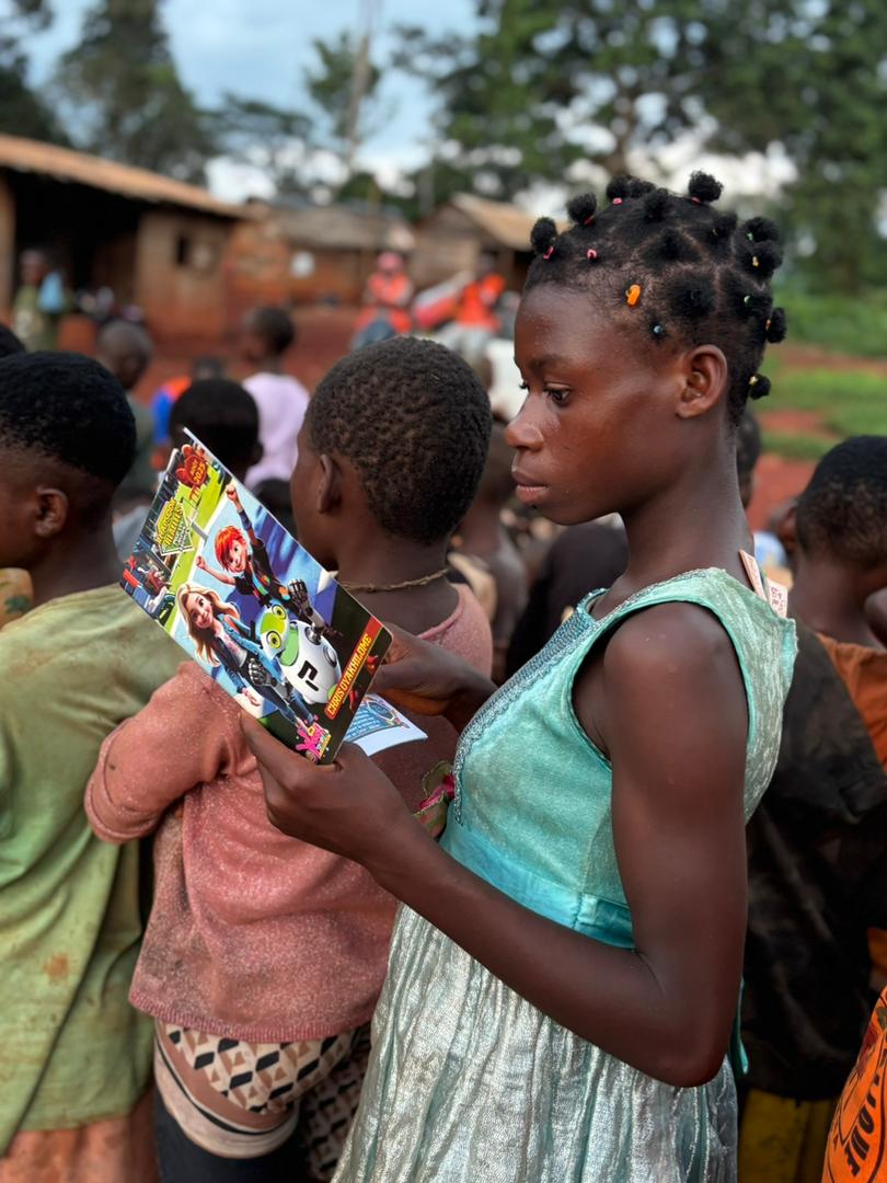 A young girl reading a children’s Rhapsody publication during an earlier outreach